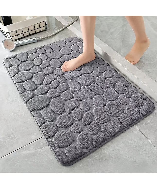 Gray textured bath mat on a bathroom floor with a person stepping onto it.