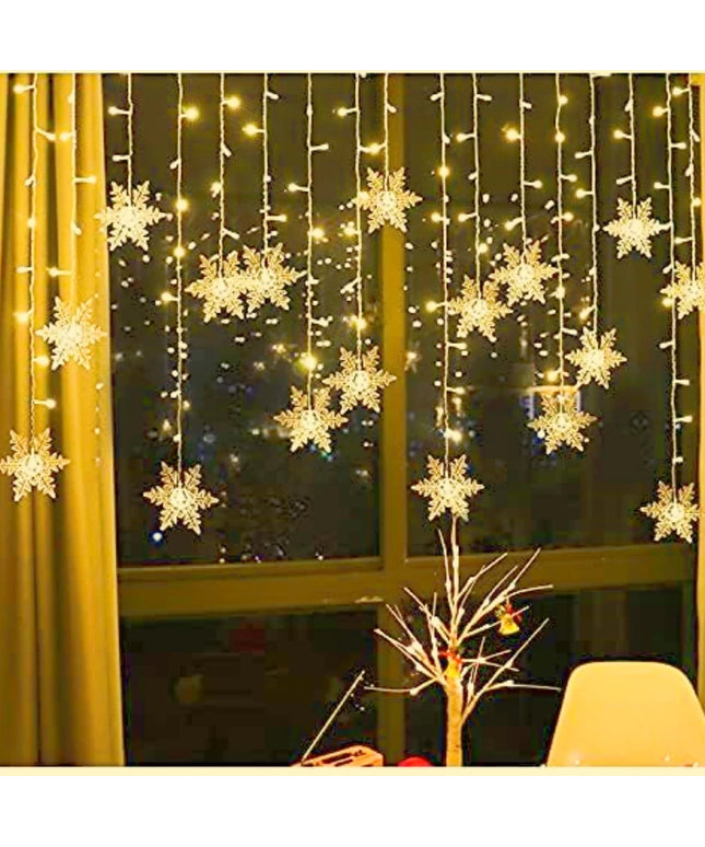 Hanging snow flake lights with a glass window background 