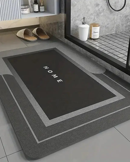 Gray bath mat with 'HOME' text on a bathroom floor