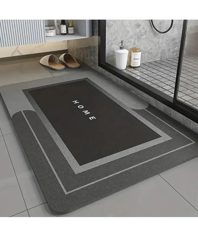 Gray bath mat with 'HOME' text on a bathroom floor