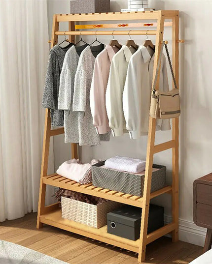 Wooden clothing rack with clothes and storage baskets in a room.