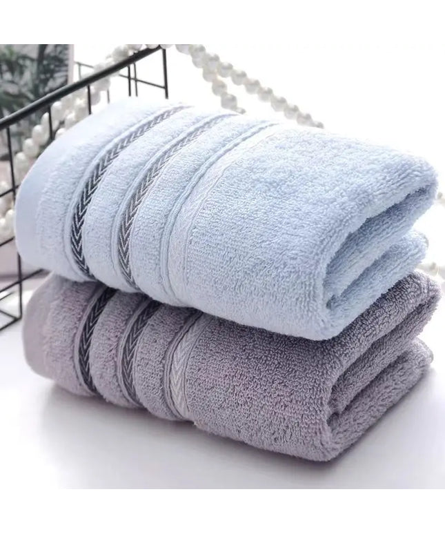 Two folded towels, light blue with decorative stripes on a white surface.