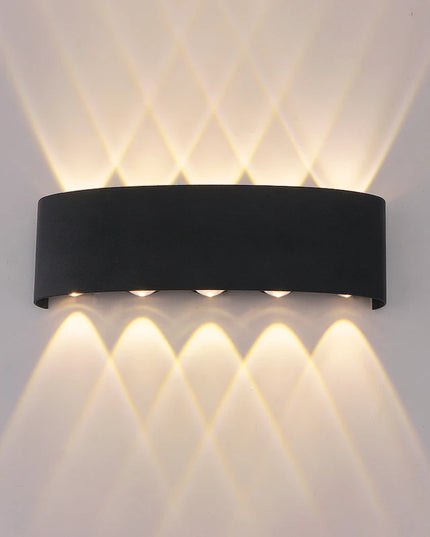 Black wall-mounted outdoor light fixture on a gray wall