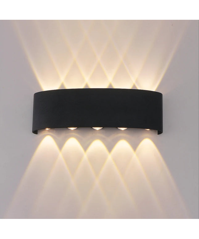 Black wall-mounted outdoor light fixture on a gray wall