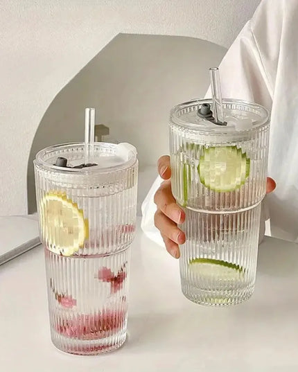 Two clear tumblers with lemon and lime slices on a light surface.
