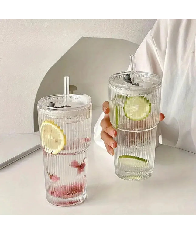 Two clear tumblers with lemon and lime slices on a light surface.