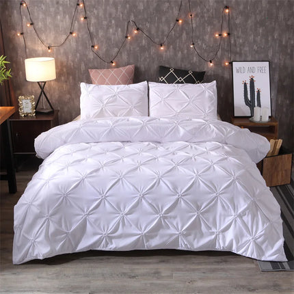 White quilted comforter set on a bed with decorative string lights and nightstands.