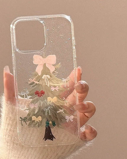 Phone case with a Christmas tree design featuring ribbons held by a hand against a beige background