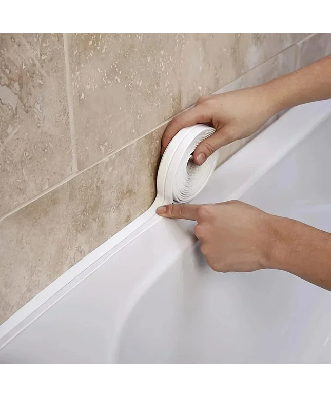Person applying white caulk to a bathroom corner.