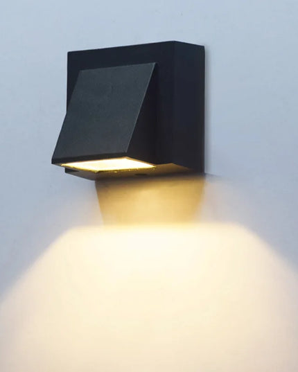 Black outdoor wall light fixture on a light gray wall