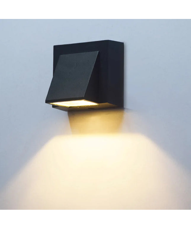 Black outdoor wall light fixture on a light gray wall