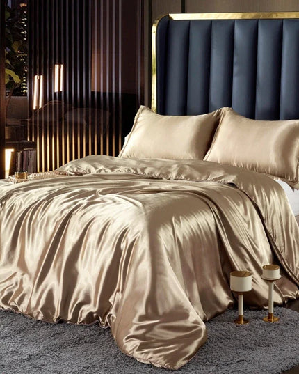 Beige satin bedding set on a bed with a dark upholstered headboard in a bedroom setting.
