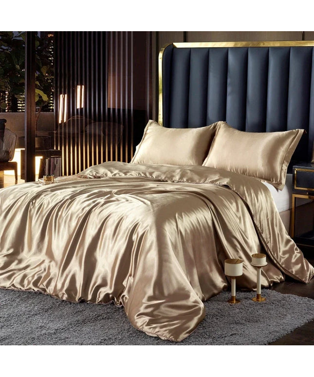 Beige satin bedding set on a bed with a dark upholstered headboard in a bedroom setting.