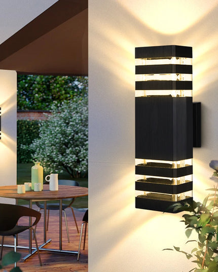 Modern outdoor wall lights on a building with a patio and garden view.