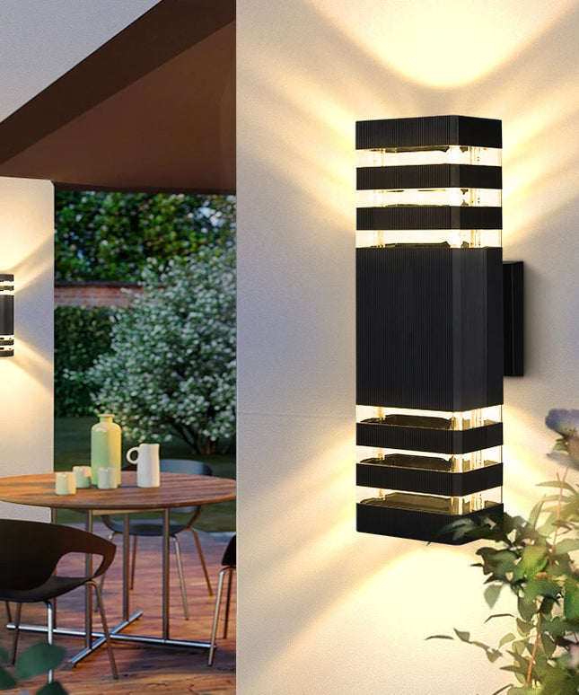 Modern outdoor wall lights on a building with a patio and garden view.