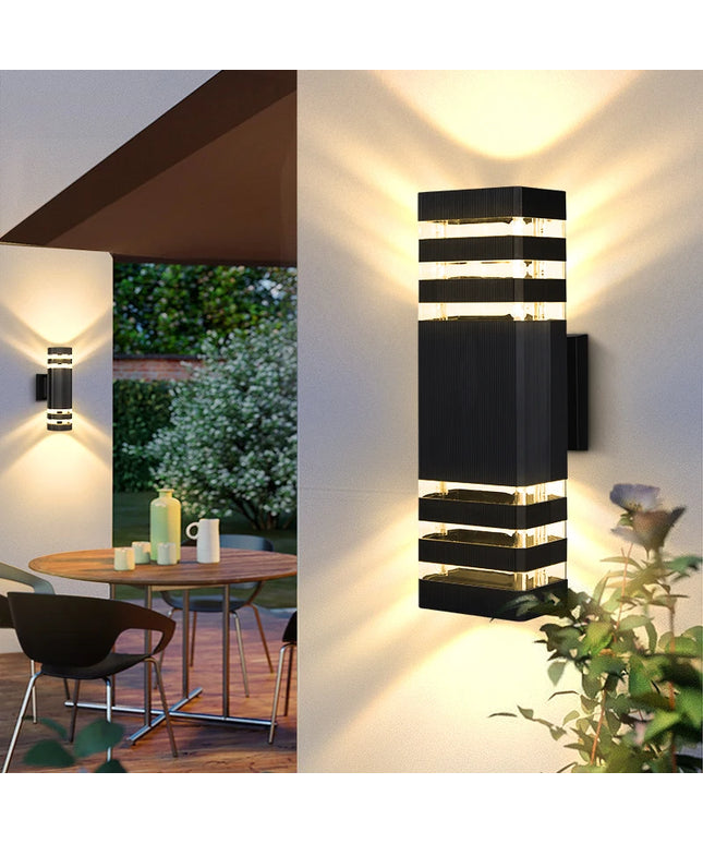 Modern outdoor wall lights on a building with a patio and garden view.