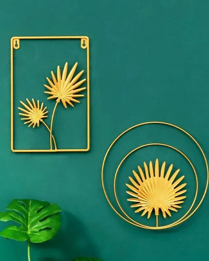 Gold leaf-shaped wall art pieces on a teal background