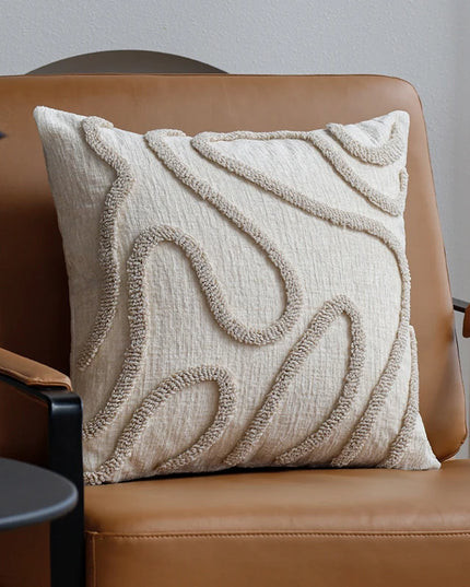 Textured beige pillow on a brown chair against a neutral background
